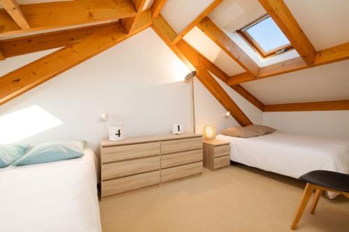 - 2 lits dans une chambre mansardée avec des plafonds en bois dans l'établissement Les Dunes - Duplex - 6 personnes, à Jullouville