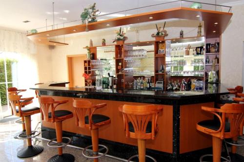 a bar with wooden stools in a room at Hotel Messeblick in Sarstedt