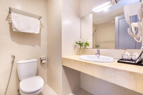 W łazience znajduje się toaleta, umywalka i lustro. w obiekcie Khách sạn Bamboo Sài gòn w Ho Chi Minh
