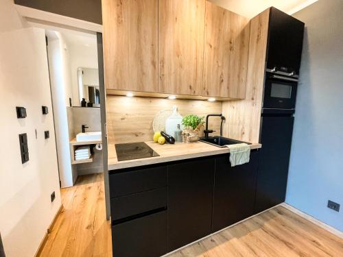 a kitchen with wooden cabinets and a sink at Tiny House mit Sauna - am Main in Wipfeld