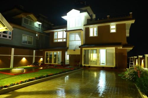 a large building with a courtyard at night at HAILSTONE HOME STAY in Ooty