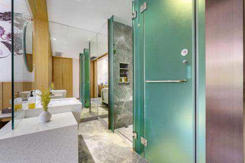 a bathroom with a shower and a blue door at 柏高酒店顺德北滘文化公园店 Paco Hotel Shunde Beijiao Midea Group Headquarters store in Shunde
