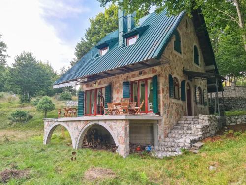 a small house with a bridge in the yard at Lovćen Escape, Rustric House in Cetinje