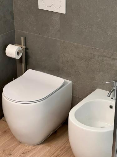 a bathroom with a white toilet and a sink at Green House in Bassano del Grappa