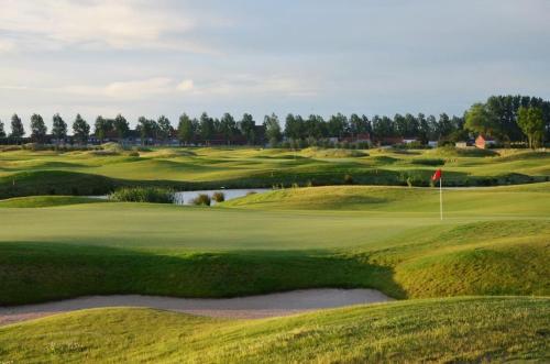 - une vue sur un parcours de golf avec un green dans l'établissement Villa Gaupin Adults Only, à Coxyde