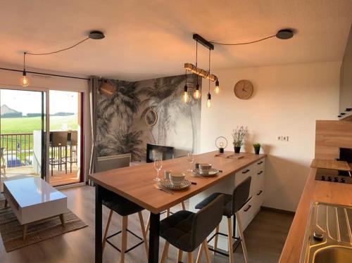 une cuisine avec une grande table et des chaises en bois dans l'établissement Appartement entièrement rénové avec vue sur océan, à Biscarrosse