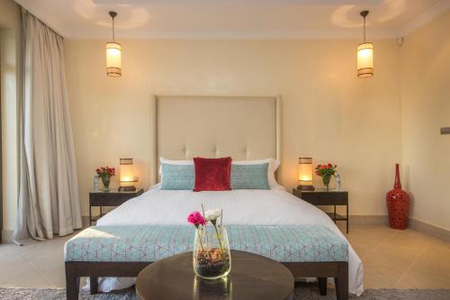 a bedroom with a large bed with two tables at Luxury Villa GoldPalm Marrakech in Marrakech