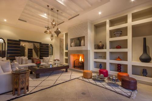 a living room with a couch and a fireplace at Luxury Villa GoldPalm Marrakech in Marrakech