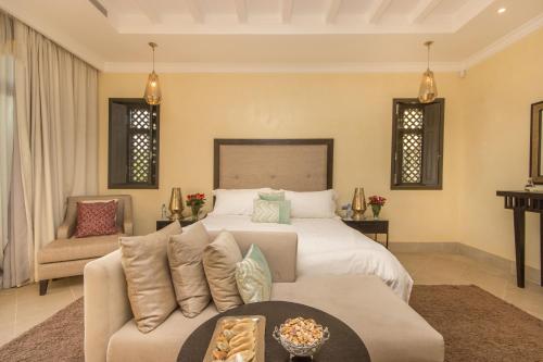 a bedroom with a bed and a couch at Luxury Villa GoldPalm Marrakech in Marrakech