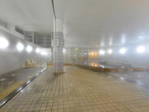 a misty building with a tile floor and a large room at HigashimaeOnsen Shinwanoyu Hotel Akitaya in Hokuto