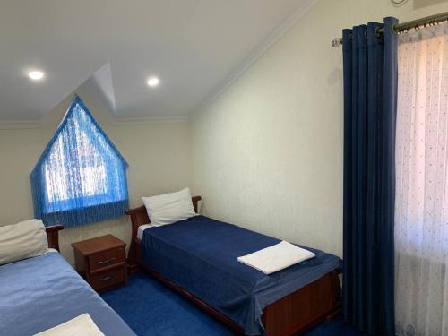 a small room with two beds and a window at Sunny Breeze in Karakkulʼtugay