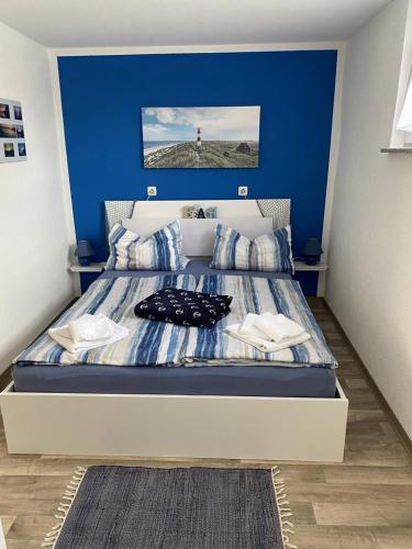 a bedroom with a bed with a blue wall at NEU! Bungalow am Kummerower See TOP in Verchen