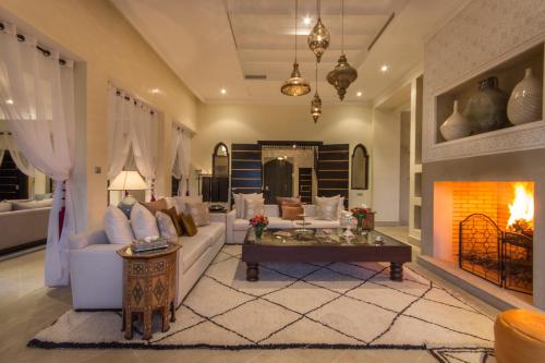 a living room with a couch and a fireplace at Luxury Villa GoldPalm Marrakech in Marrakech