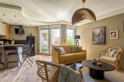 ein Wohnzimmer mit einem Sofa und einem Tisch in der Unterkunft Appartement spacieux avec balcon 6pers in Lyon