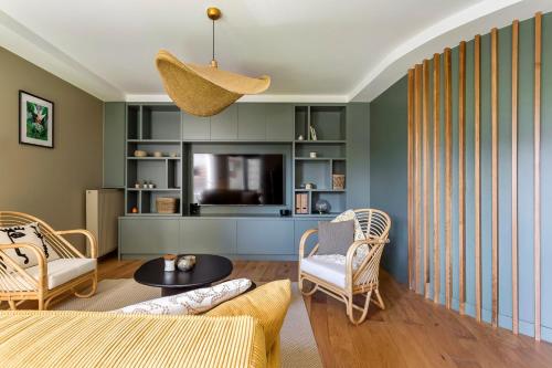 a living room with a couch and chairs and a television at Appartement spacieux avec balcon 6pers in Lyon