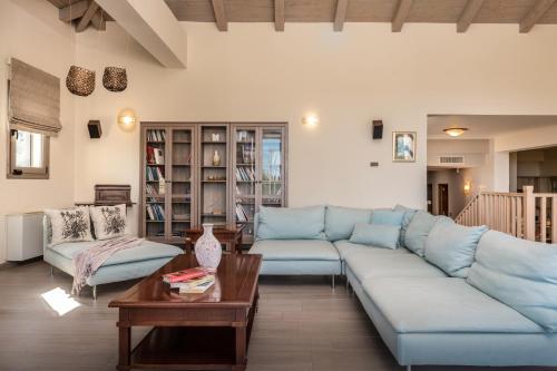 a living room with a blue couch and a table at Astarte Villas - Stilvi 4 Bedroom Private Villa With Pool in Akrotiri
