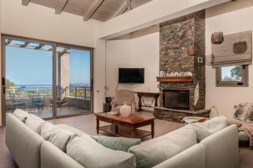 a living room with a couch and a fireplace at Astarte Villas - Stilvi 4 Bedroom Private Villa With Pool in Akrotiri