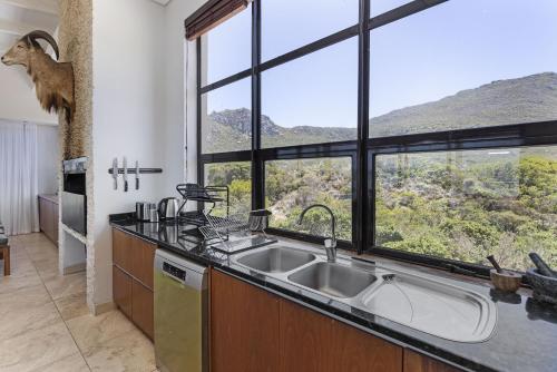 a kitchen with a sink and a large window at Hangklip Villa by Host Agents in Pringle Bay