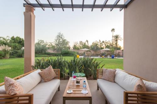 a patio with two white couches and a table at Luxury Villa GoldPalm Marrakech in Marrakech