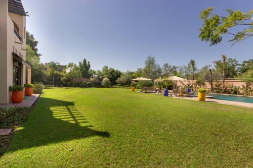 a large yard with green grass next to a building at Luxury Villa GoldPalm Marrakech in Marrakech