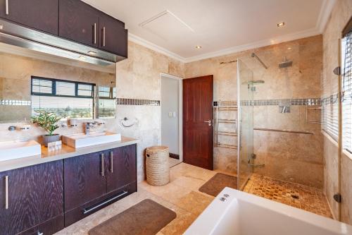 a bathroom with two sinks and a shower at Luxury 3 bedroom Duplex Penthouse with communal swimming pool in Bloubergstrand