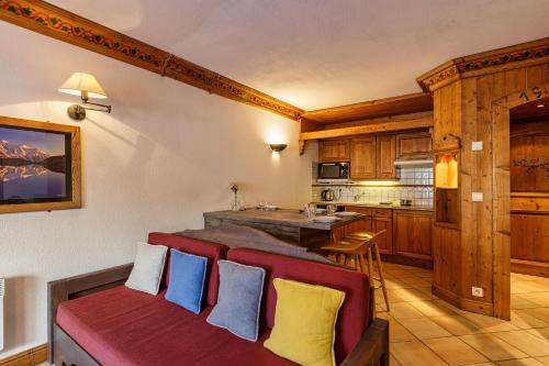 a living room with a couch and a kitchen at Résidence Le Cristal - Grands Montets 7 - Happy Rentals in Chamonix