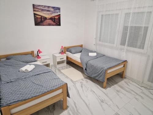 a bedroom with two beds and a bridge picture on the wall at Sobe kuća za odmor apartmani Auto Klarić in Nova Gradiška