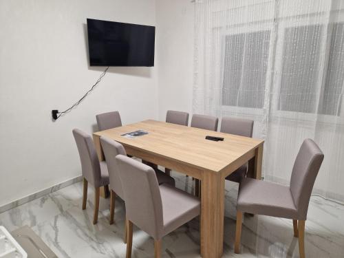 comedor con mesa de madera y sillas en Sobe kuća za odmor apartmani Auto Klarić, en Nova Gradiška