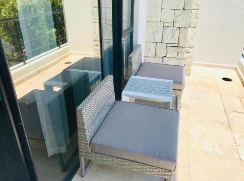 two chairs and a table on a patio at Pearl Valley Golf lodge in Paarl