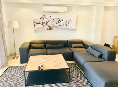 a living room with a blue couch and a table at Pearl Valley Golf lodge in Paarl