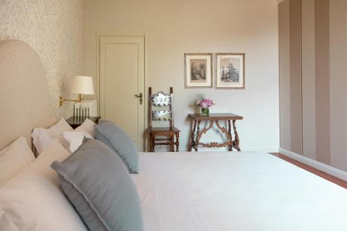 ein Schlafzimmer mit einem großen weißen Bett mit blauen Kissen in der Unterkunft PODERI LA ROCCHETTA Luxury Villa on the Hills of Lake Garda in San Felice del Benaco