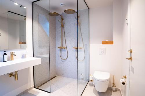 a bathroom with a shower with a toilet and a sink at Sixtus Sinatur Hotel & Konference in Middelfart