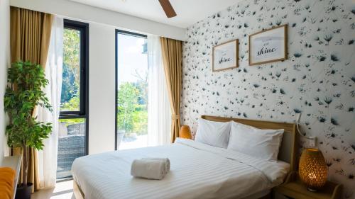 a bedroom with a bed with a bird patterned wall at Cassia Residences in Bang Tao Beach