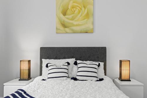 a bedroom with a bed with two lamps and a yellow rose at Peaceful Country Retreat in Moutoa