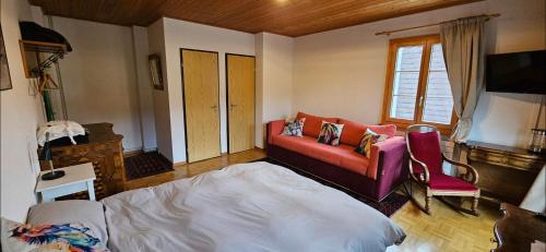 a living room with a couch and a bed at Miramont Horse Trekking Hostel in Saicourt