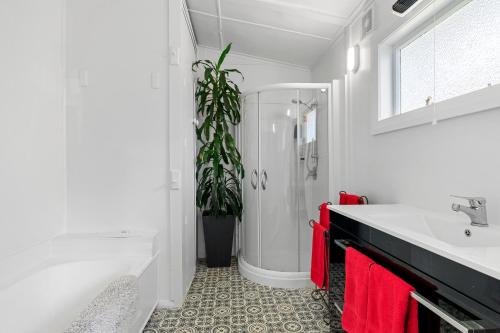 a white bathroom with a sink and a potted plant at Peaceful Country Retreat in Moutoa