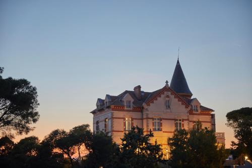 ein Gebäude mit einem Turm darüber in der Unterkunft Château Capitoul in Narbonne