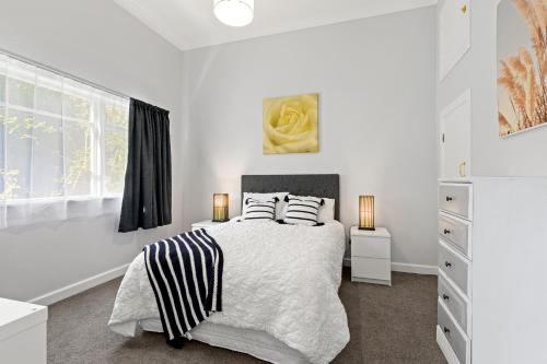 a white bedroom with a bed with two pillows at Peaceful Country Retreat in Moutoa
