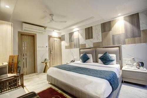 a bedroom with a large bed with blue pillows at Hotel International Inn - Near Delhi Airport in New Delhi