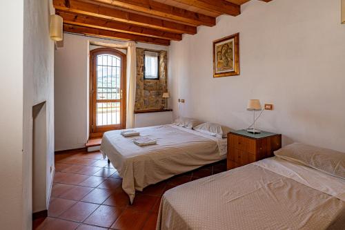 1 dormitorio con 2 camas y ventana en Lago di Iseo - Lake View House (Casa sul Lago) en Tavernola Bergamasca