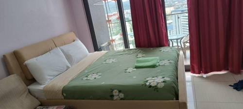 uma cama com um cobertor verde com flores em The Elements @ Ampang em Kuala Lumpur
