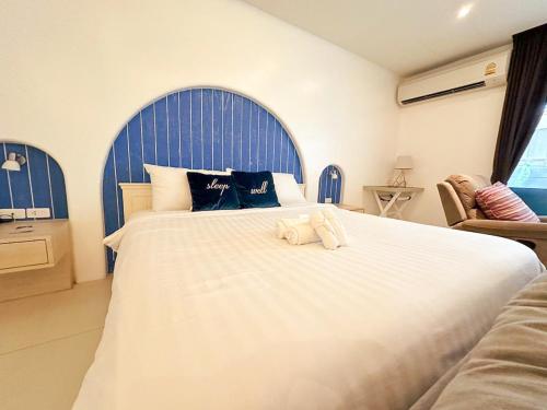 a bedroom with a large white bed with a blue headboard at Costa Beach Residence & Jacuzzi in Sattahip