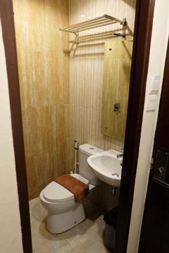 a bathroom with a toilet and a sink at HOTEL MY HOME SINTANG in Sintang