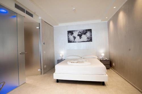 a bedroom with a white bed and a painting on the wall at Catania Sea Palace Hotel in Catania