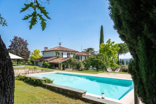 ein großer Pool vor einem Haus in der Unterkunft PODERI LA ROCCHETTA Luxury Villa on the Hills of Lake Garda in San Felice del Benaco