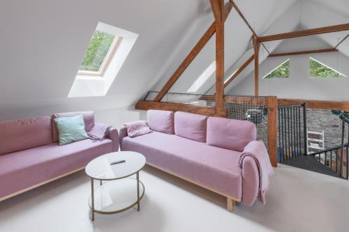 a living room with a purple couch and a table at Koblitzer Hof in Liběšice