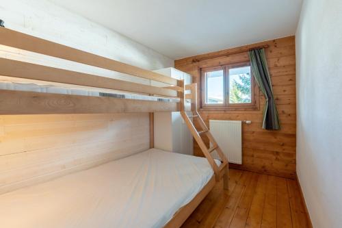 a bedroom with two bunk beds and a window at Lapon H10 in Hauteluce