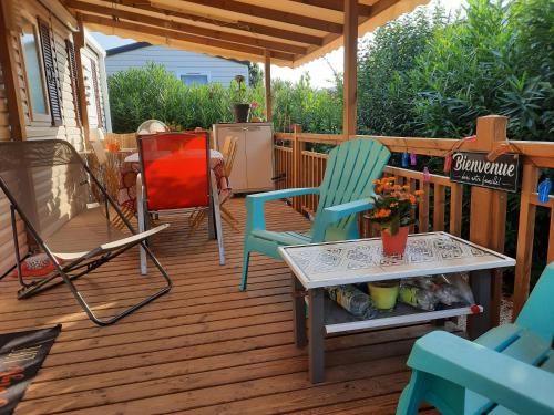 a deck with two chairs and a table and a stove at Mobilhome 8 pers in Fréjus