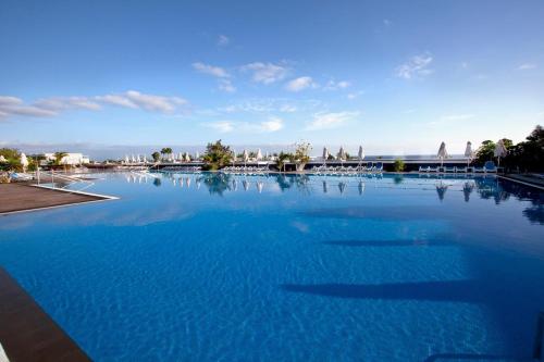 een groot zwembad met blauw water bij Hotel Costa Calero Thalasso & Spa in Puerto Calero