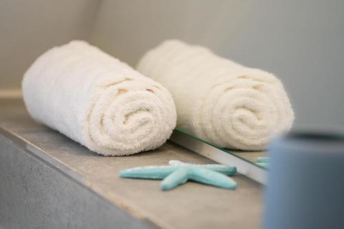 a couple of rolled towels on a counter with a toothbrush at MeerVerliebt C in Hörnum